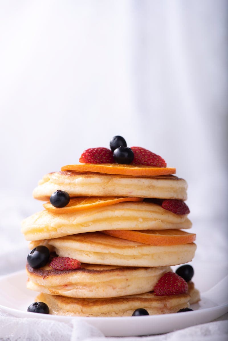 Pancakes with strawberries, blueberries, and orange slices